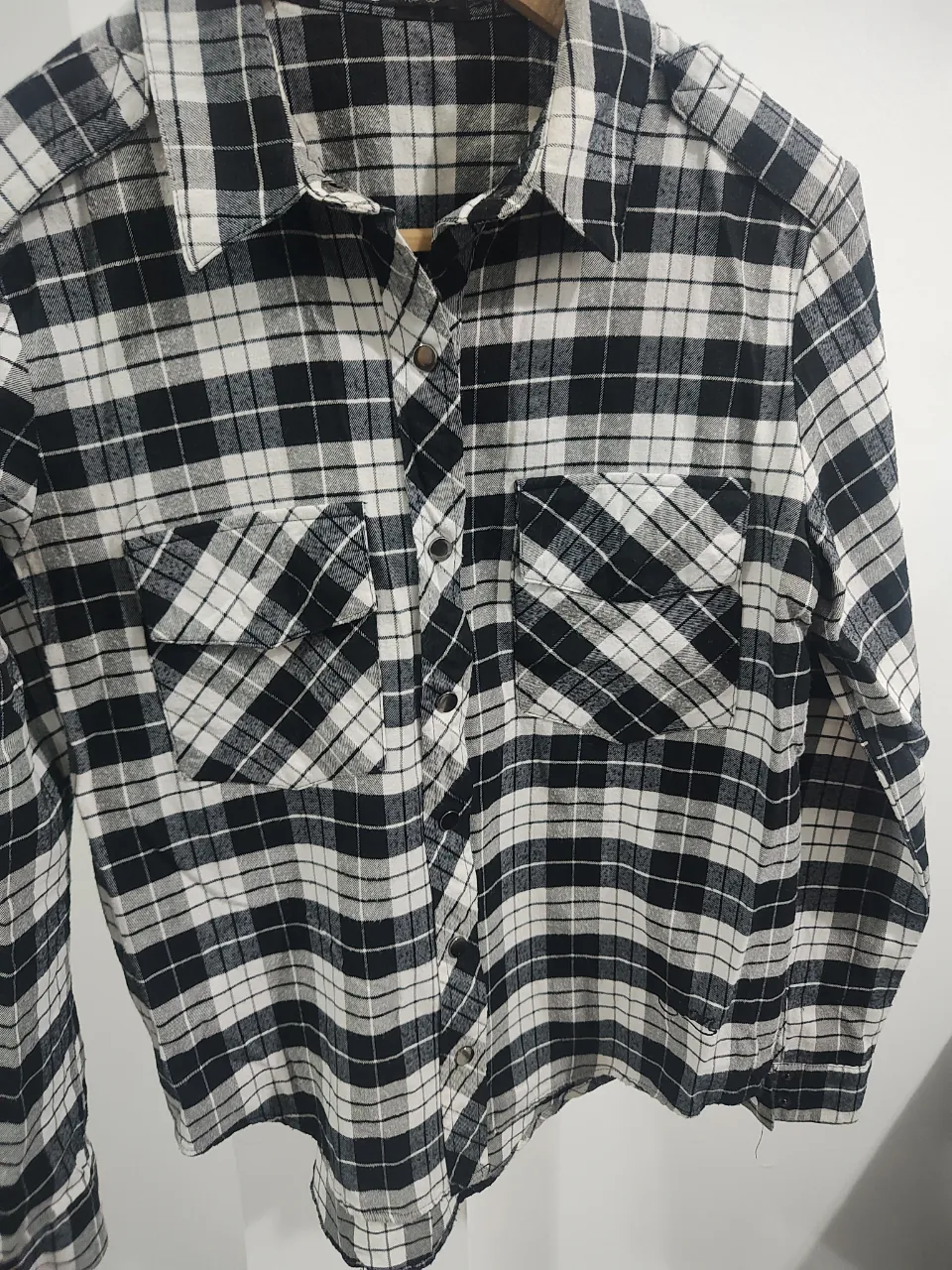 Camisa de cuadros escoceses en blanco y negro, con dos bolsillos en el frente y botones metálicos. Un clásico que nunca pasa de moda, ideal para un look casual y canchero. Talle S , va para M. Es un modelo suelto.