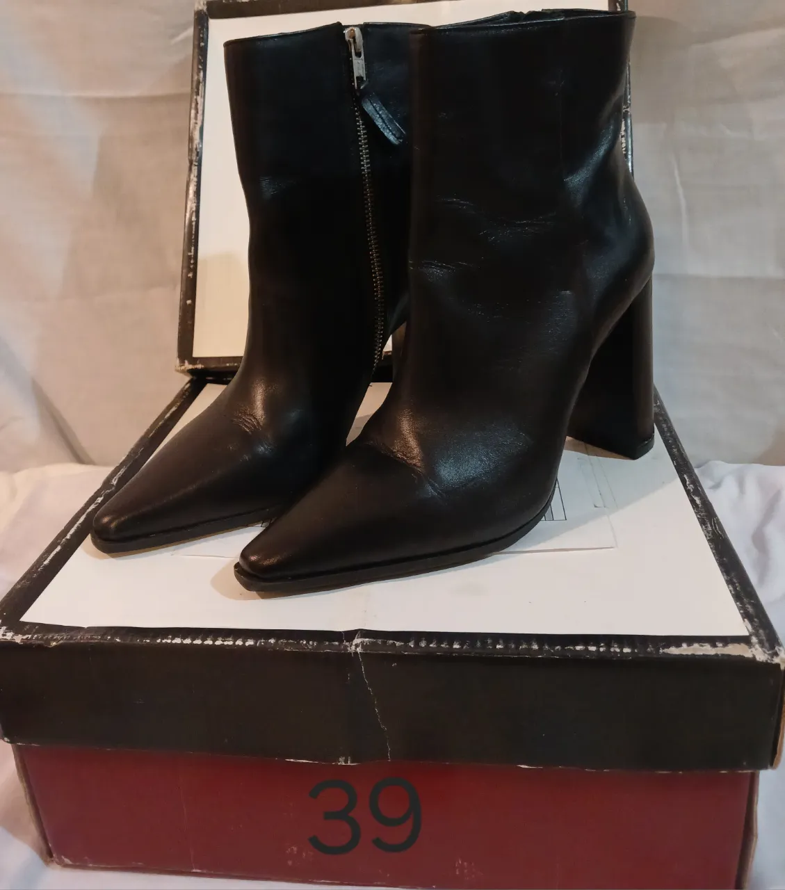 Botines negros de cuero con taco alto y punta fina. Cierre lateral para un ajuste perfecto. Ideales para un look elegante y sofisticado.
