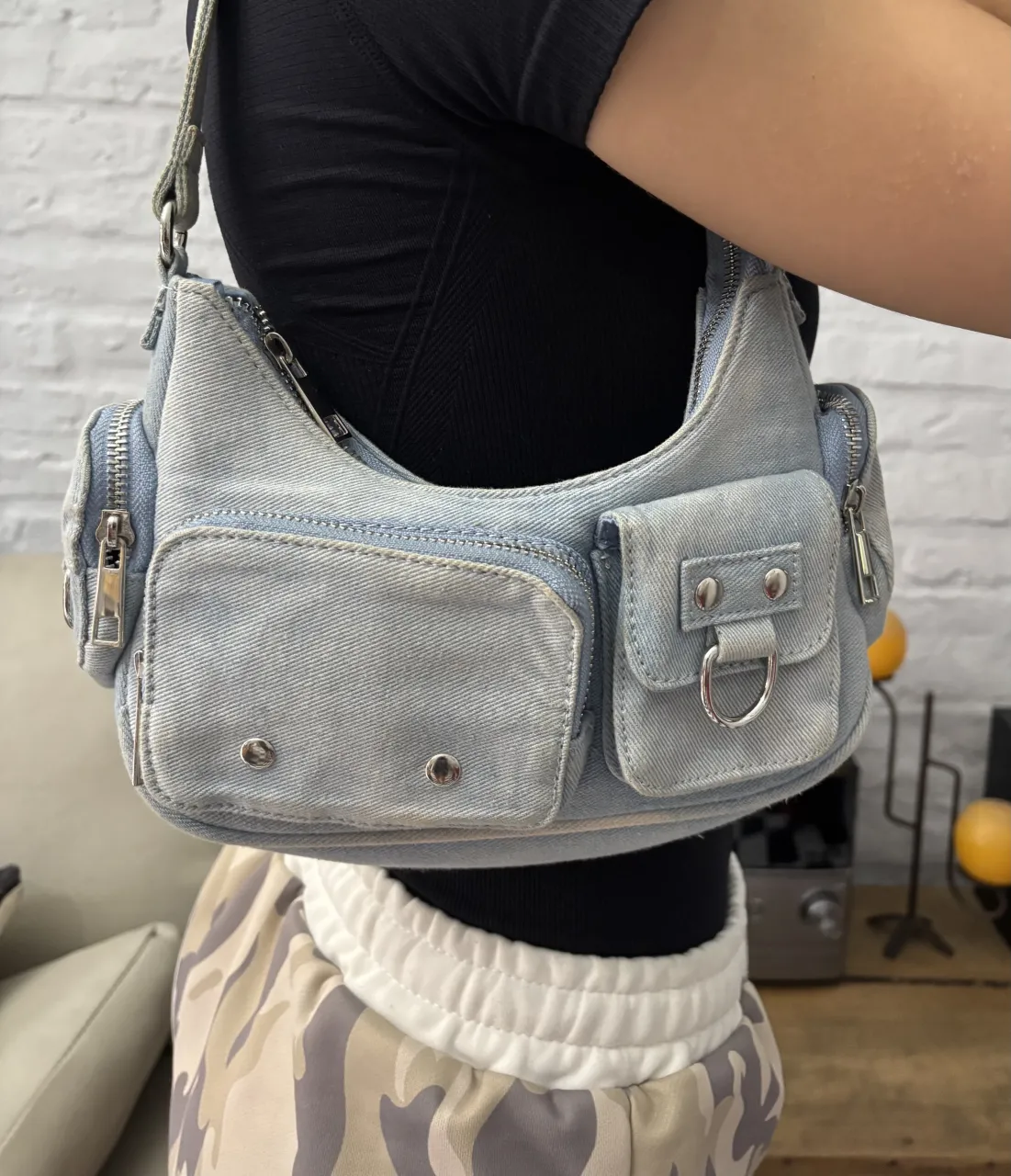 Bolso de jean estilo Y2K. Tiene varios bolsillos con cierre y detalles metálicos.