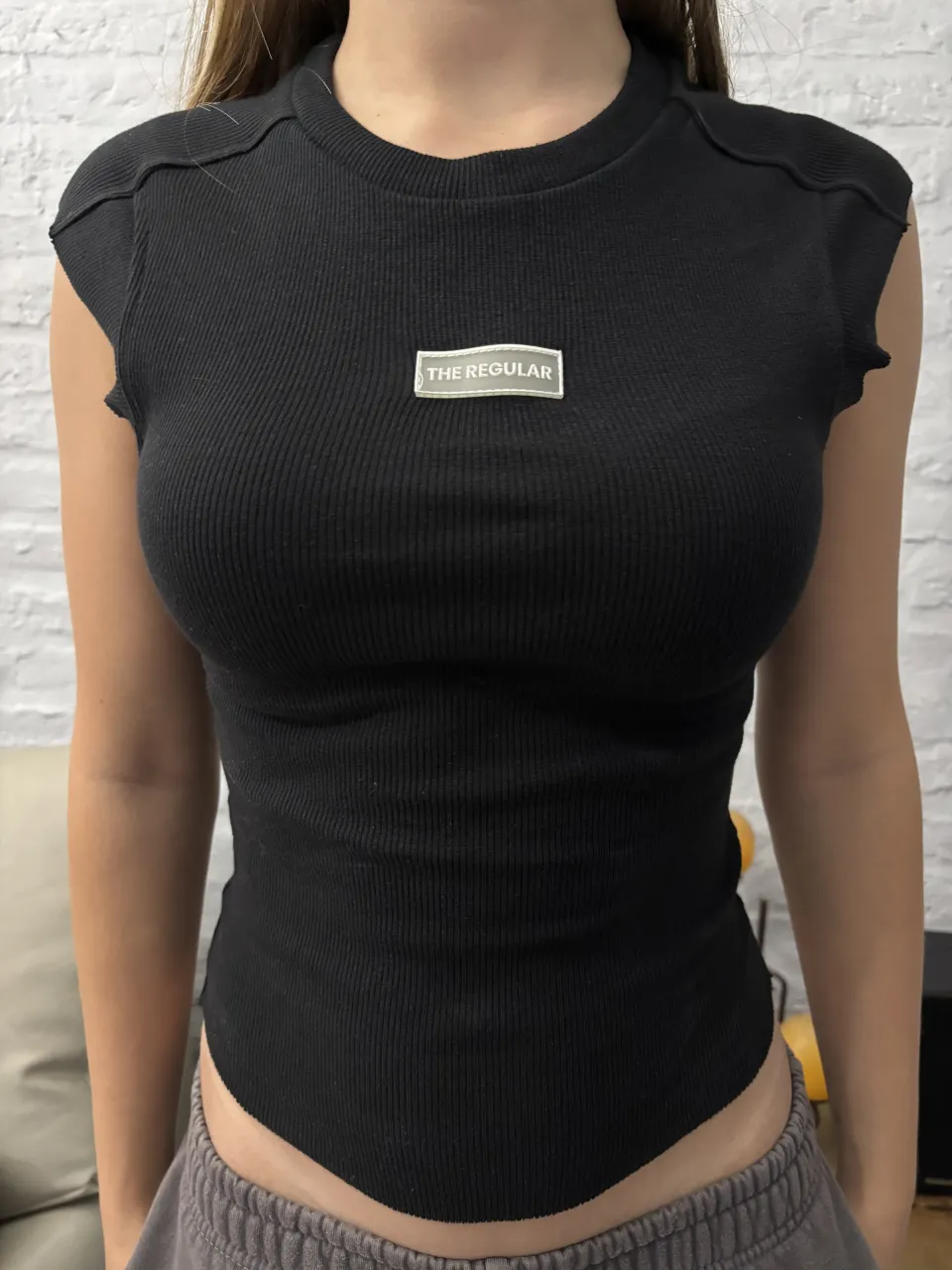 Remera negra de tejido acanalado con cuello redondo y mangas cortas. Posee un pequeño logo rectangular con el texto "THE REGULAR" en el frente. sin usos 100% algodon 