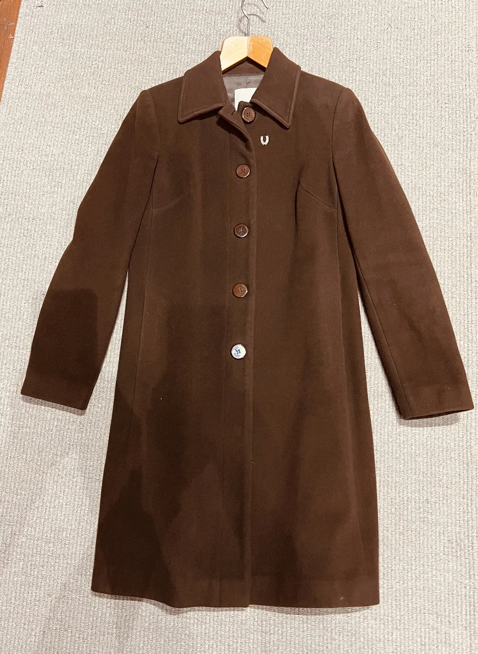 Tapado de paño marrón Portsaid, con botones y corte clásico. Ideal para un look elegante y abrigado en invierno.