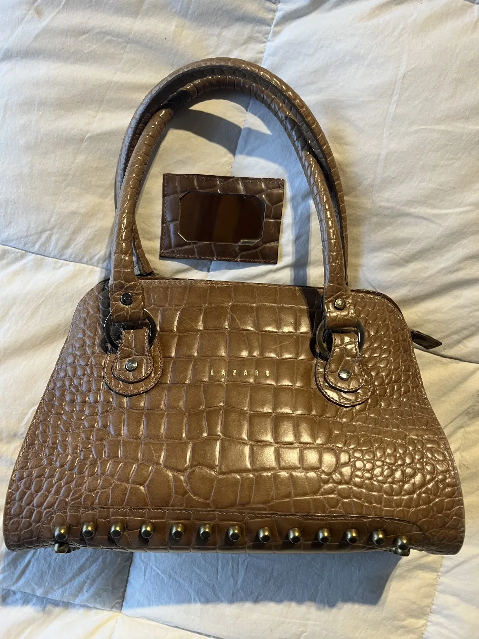 Cartera Lazaro marrón con textura de cocodrilo, incluye tarjetero a juego. Detalles dorados en la base y asas.