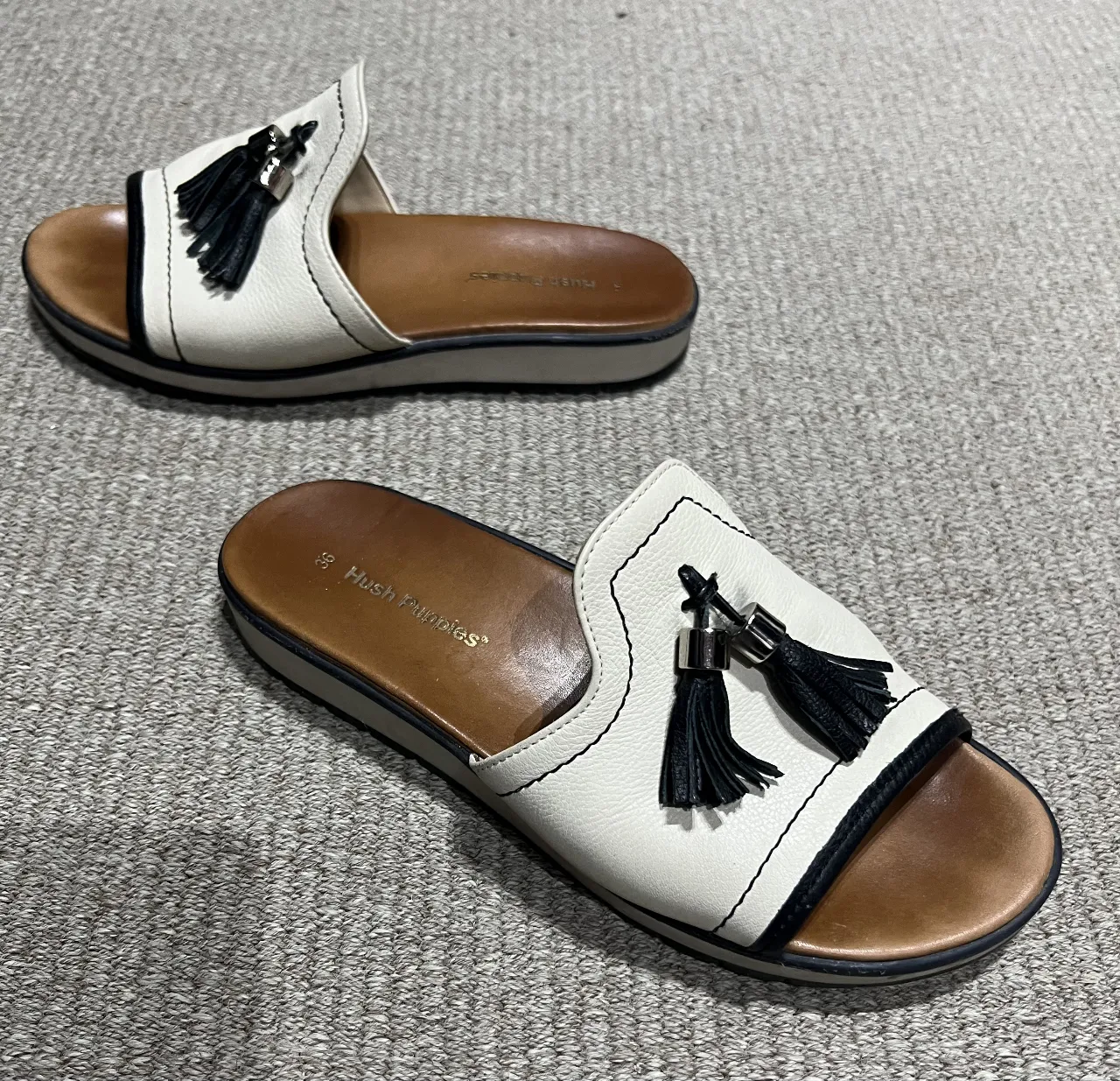 Sandalias Hush Puppies crudas con detalles en negro y borlas. Talle 36. Ideales para un look casual y cómodo.