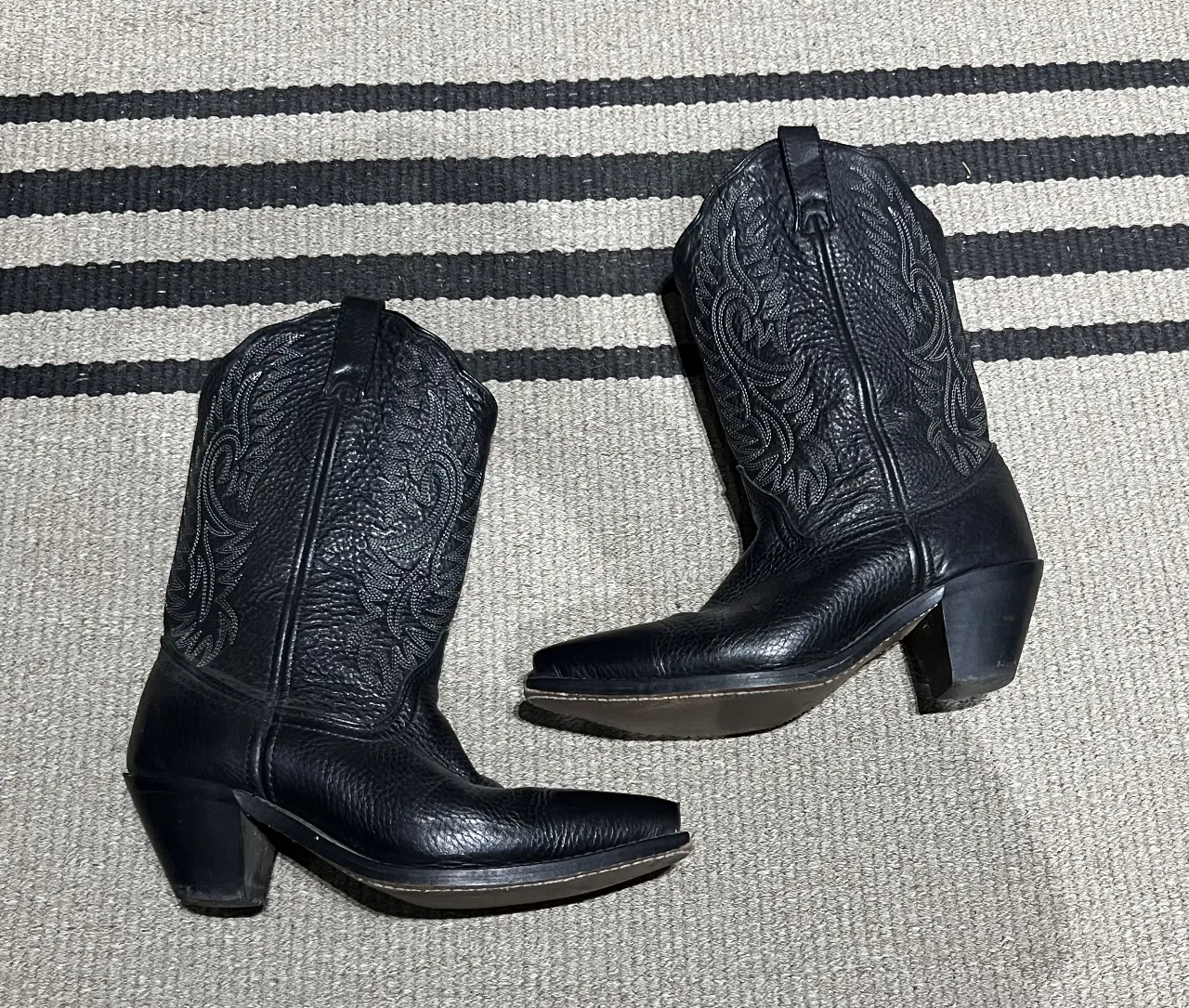 Botas texanas  de cuero negro con detalles bordados. Caña alta y taco cuadrado. Ideales para un look western o casual.