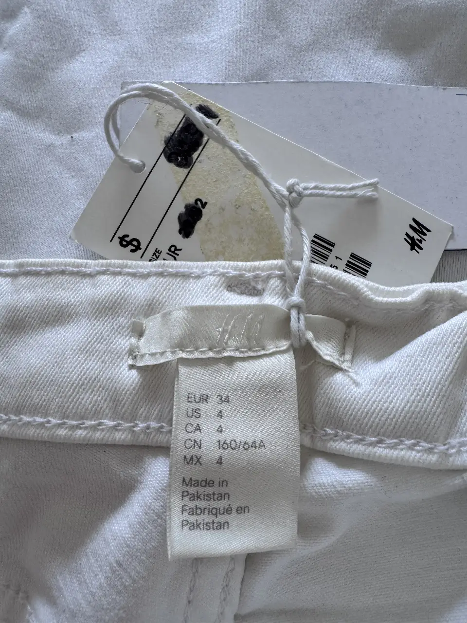 Pantalón de jean blanco, corte chupin con detalles de cierres en los bolsillos delanteros y en los tobillos. Ideal para un look casual y moderno. tiro bajo/medio 