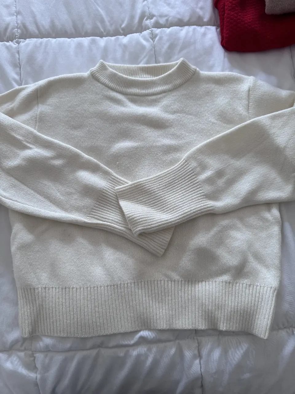 Sweater de cuello redondo en color blanco, bien corto ideal para un look casual y abrigado. Perfecto para el invierno.