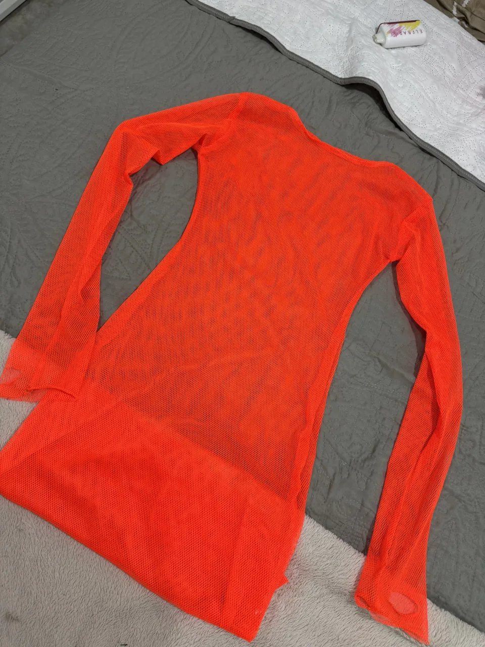 Vestido naranja de red con mangas largas.