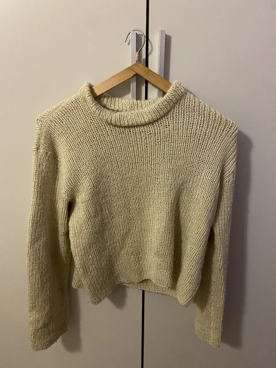 Sweater de cuello alto tejido en color crudo, ideal para un look casual y abrigado. Perfecto para el invierno.