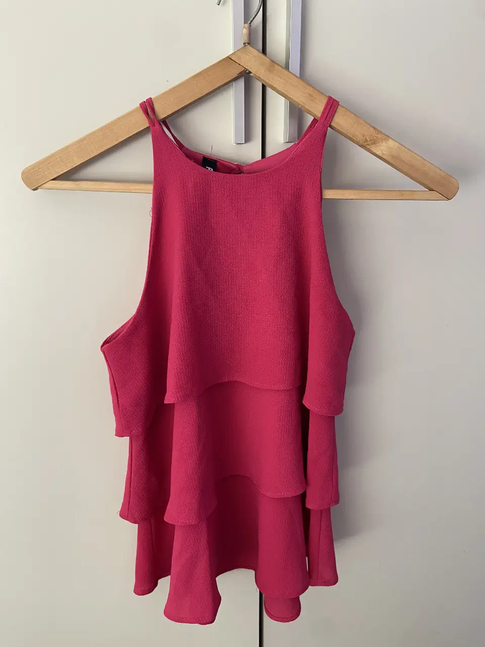 Top rosa con volados, ideal para un look fresco y femenino. Perfecto para combinar con jeans o faldas.