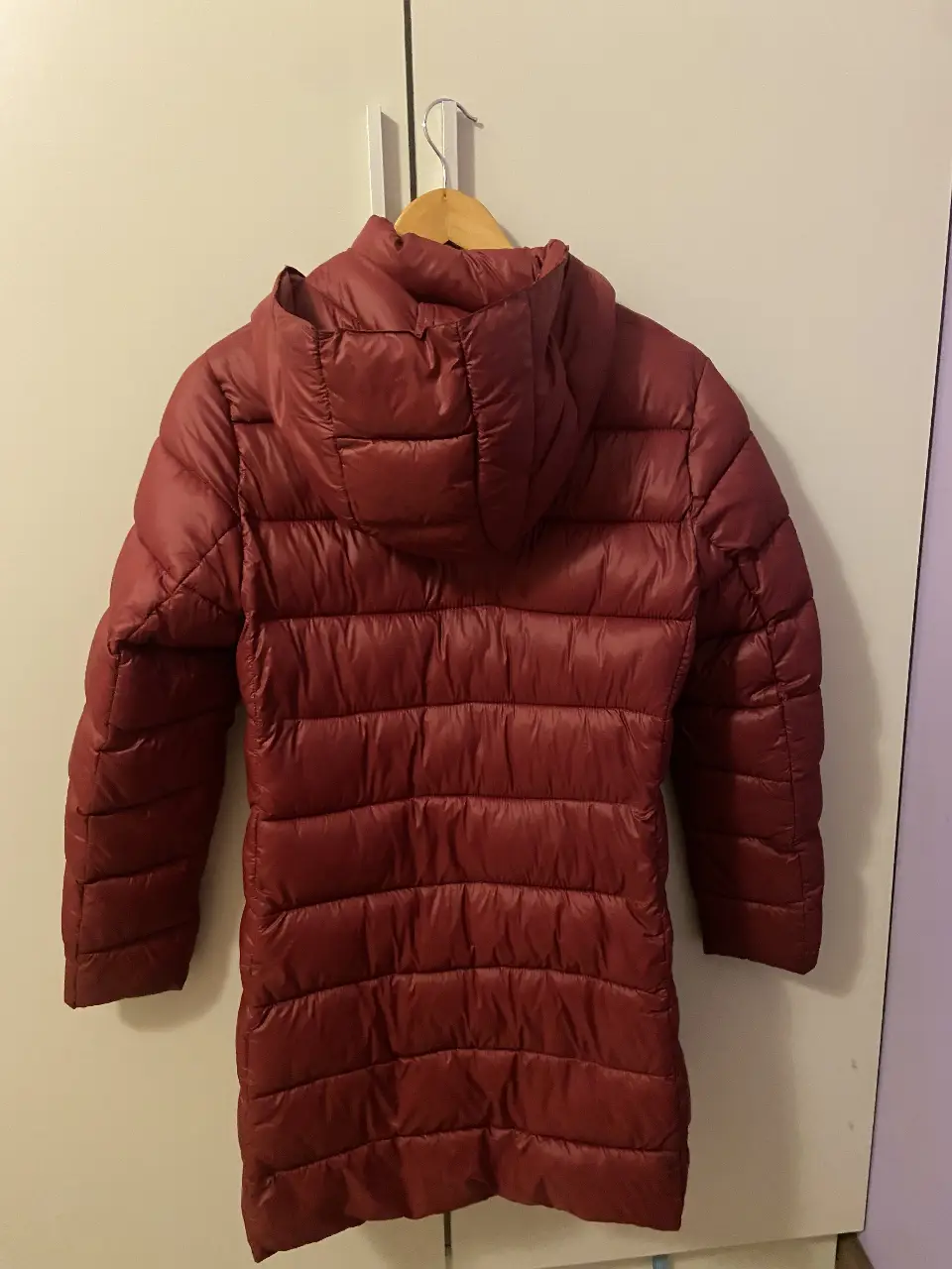 Campera de pluma roja, ideal para el invierno. Con capucha y cierre frontal. Perfecta para mantenerte abrigada y cómoda.