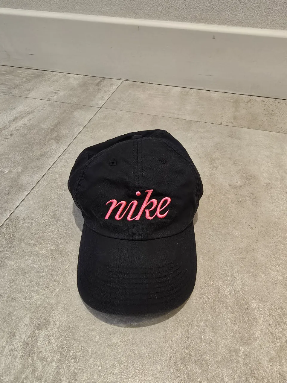 Gorra negra de algodón y poliéster con logo de Nike bordado en color rosa.