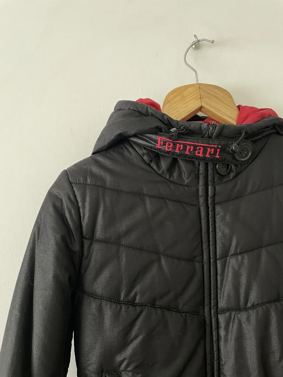 Campera negra con capucha y forro rojo, con detalles de la marca Ferrari en el pecho. Ideal para el invierno, abrigada y con estilo.

Es un xs pero para un s también iría 