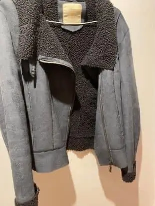 Campera de mujer, color gris. Confeccionada en material símil cuero gamuzado, con detalles de piel sintética en cuello y puños. Cierre asimétrico y detalles de costura. Ideal para un look casual y abrigado en invierno.