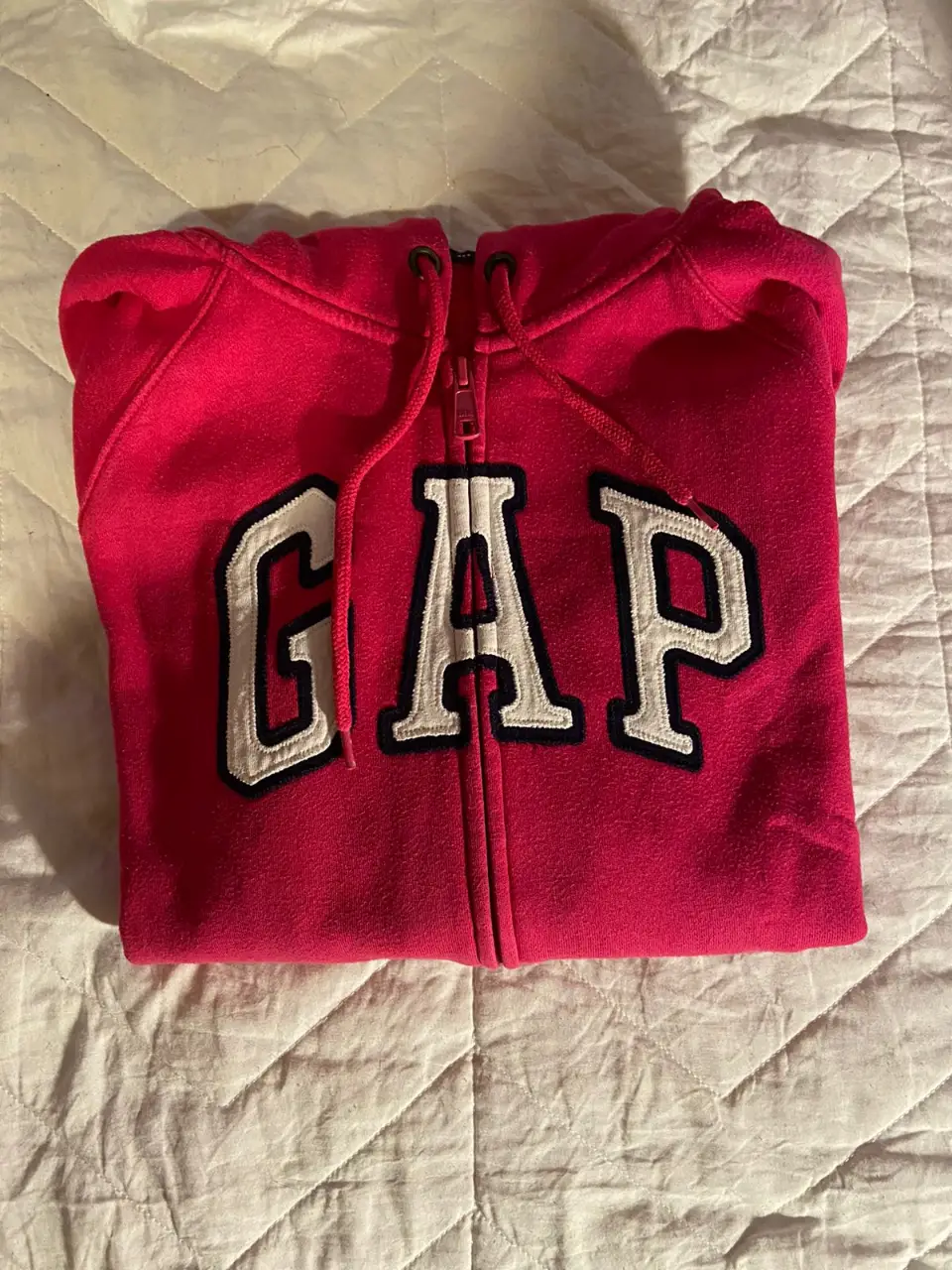 Buzo con cierre de la marca Gap, color rosa chicle con el logo de la marca en blanco. Talle S.