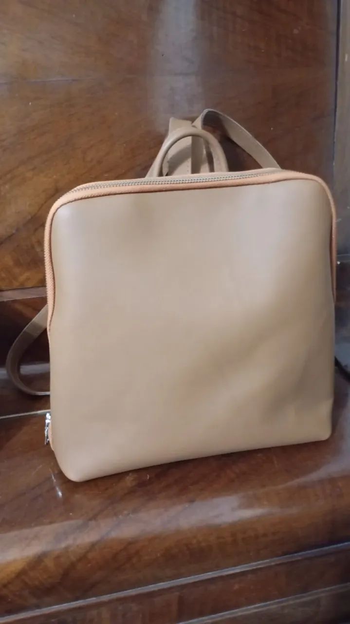 Mochila de cuero color suela, súper práctica y canchera. Tiene un bolsillo frontal con cierre y correas regulables. Ideal para el día a día, para llevar todo lo que necesitás con estilo.