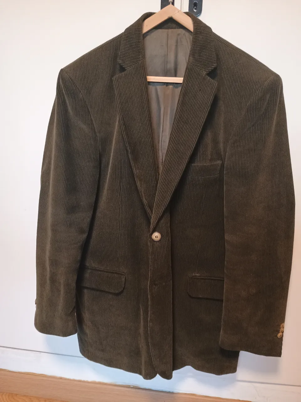 Blazer de hombre de corderoy color verde oscuro, con dos botones y bolsillos delanteros. Ideal para un look elegante y vintage.
