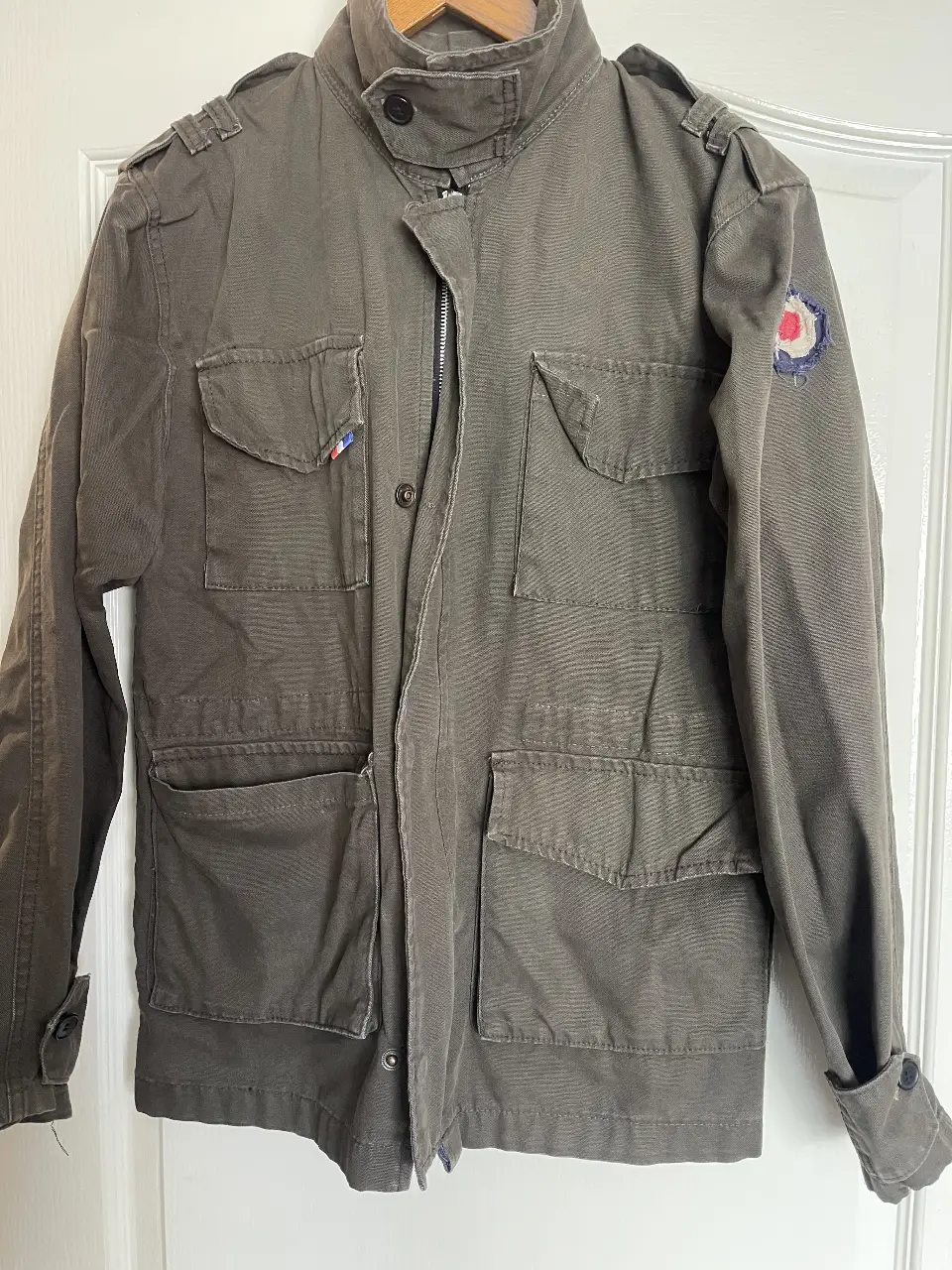 Chaqueta militar de hombre en color gris. Con múltiples bolsillos y parches decorativos. Ideal para un look casual y utilitario.