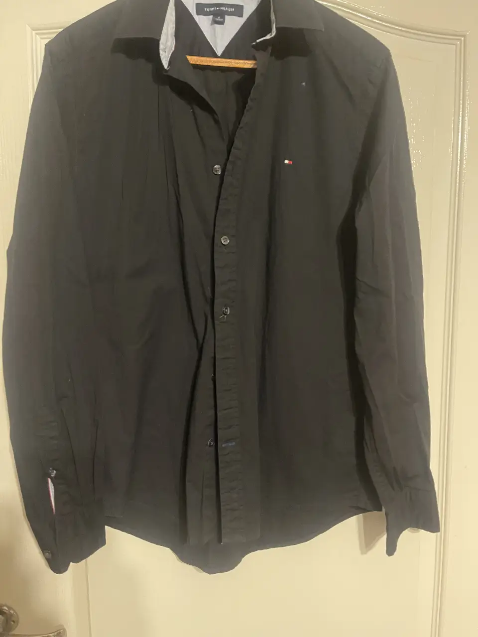 Camisa negra de hombre Tommy Hilfiger, manga larga, con el logo de la marca bordado en el pecho. Ideal para un look casual o semi formal.