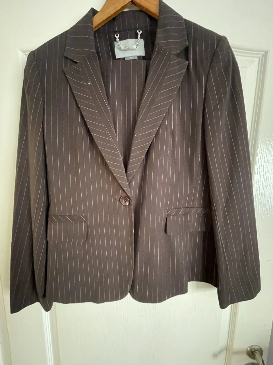 Traje de pantalón sastrero a rayas marrón. Blazer con un botón y bolsillos. Pantalón con dos botones y bolsillos.