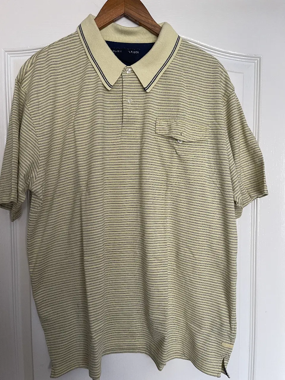 Remera polo Tommy Hilfiger a rayas horizontales en tonos amarillo y azul. Con bolsillo en el pecho y cuello. Ideal para un look casual y fresco.