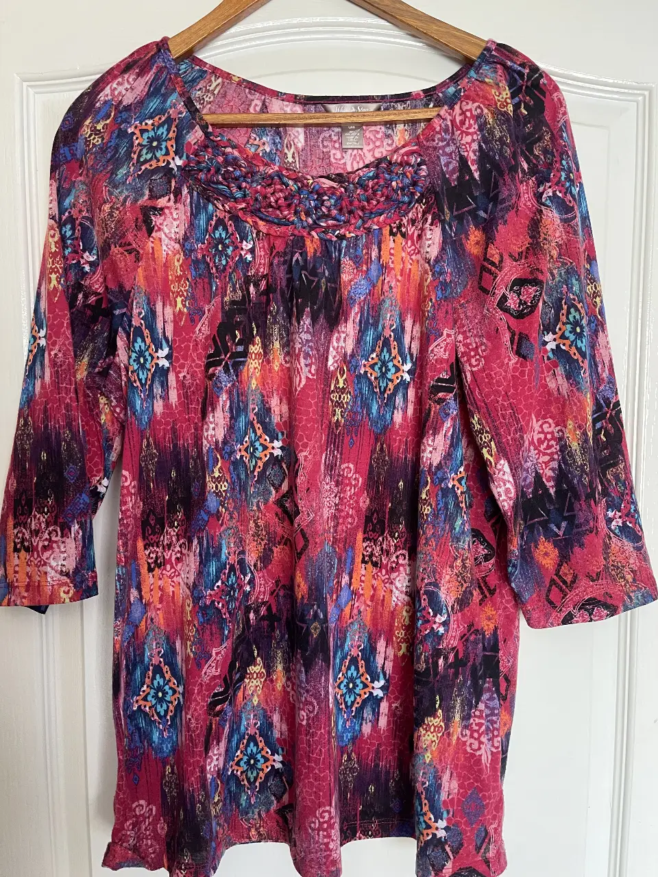 Blusa estampada con mangas 3/4 y cuello redondo con detalle trenzado. Ideal para un look casual y con estilo.
