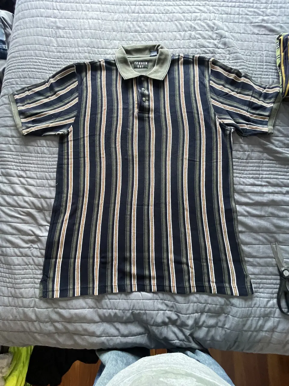 Remera polo a rayas verticales, con cuello y mangas en verde. Ideal para un look casual y cómodo.