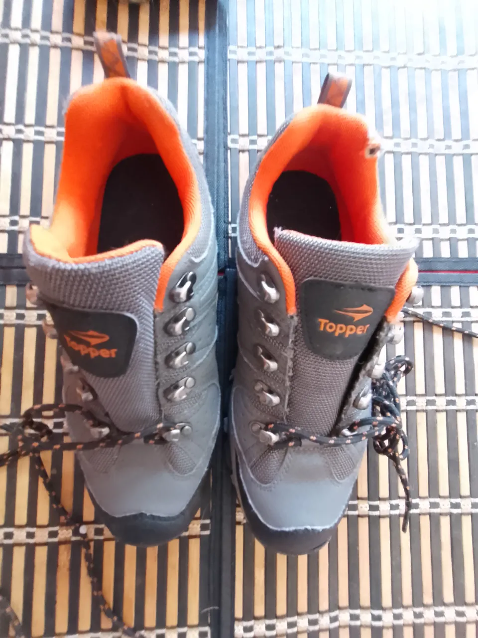 Zapatillas de trekking grises con detalles en naranja. Marca Topper.