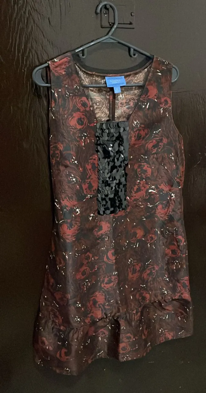 Vestido sin mangas de la marca Simply Vera Vera Wang, con estampado floral en tonos marrones y rojos. Detalles de lentejuelas negras en el frente y un lazo en la espalda.