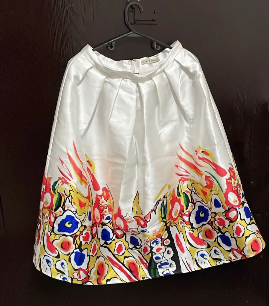 Pollera larga de satén blanco con estampado floral multicolor. Ideal para un look elegante y llamativo.