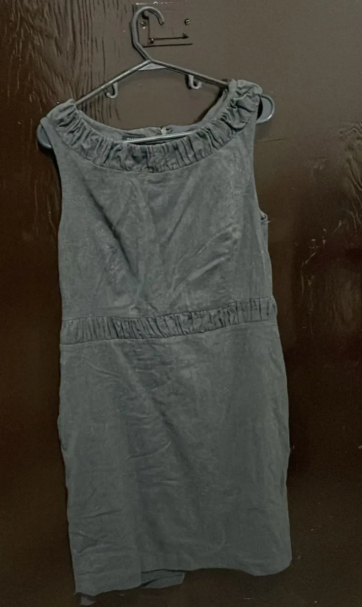 Vestido midi gris de la marca Talbots, talle 10. Diseño con cuello redondo con volados, detalle fruncido en la cintura y cierre trasero. Ideal para un look elegante y sofisticado.