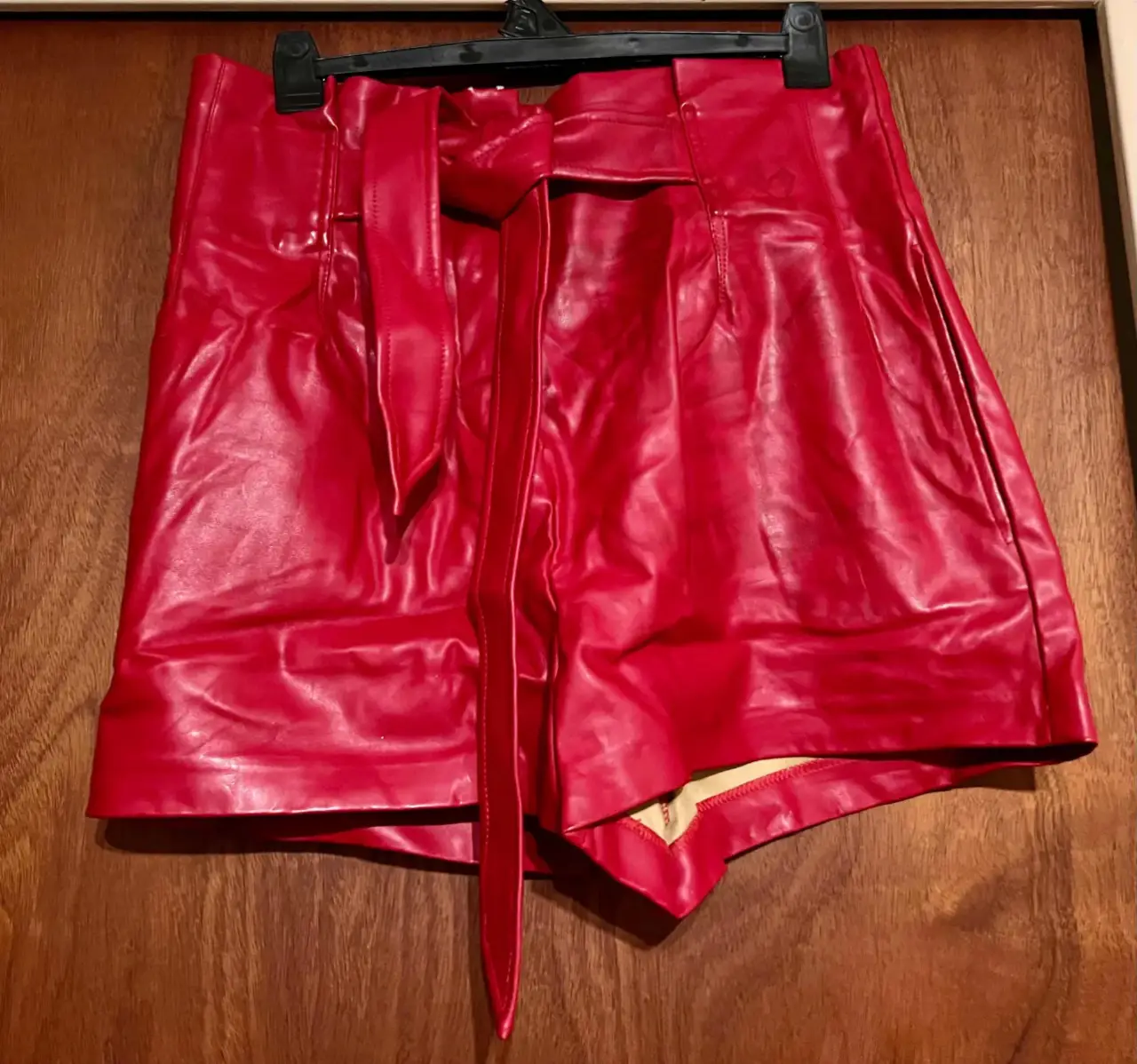 Shorts de cuero sintético rojo tiro alto con cinturón. Ideal para un look de fiesta o salida.