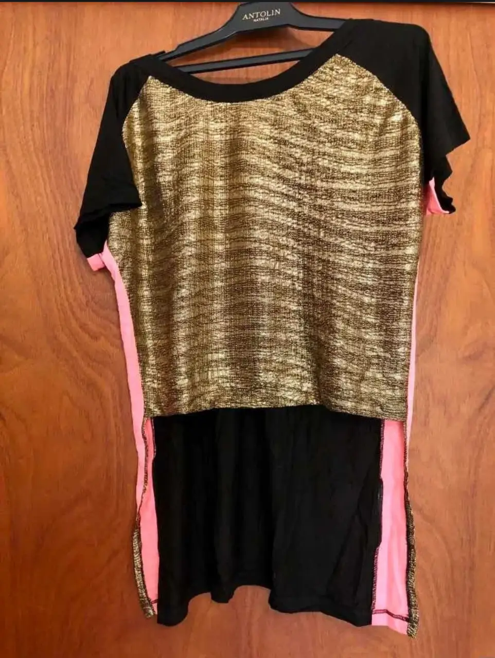 Remera de mujer con mangas cortas y detalles dorados en la parte superior. Diseño moderno y versátil para un look casual.