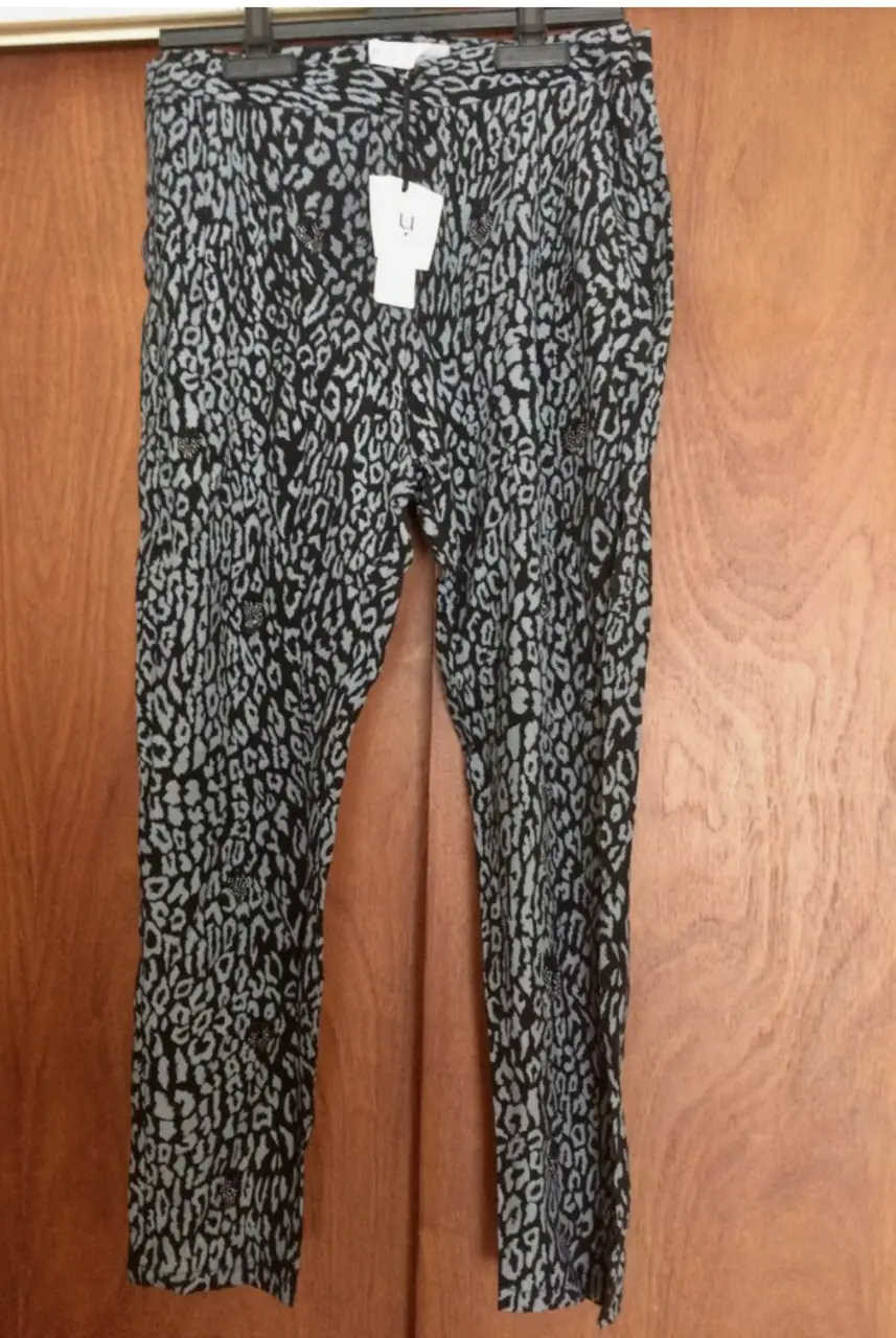 Pantalón suelto con estampado de leopardo en tonos grises y negros. Ideal para un look casual y moderno.