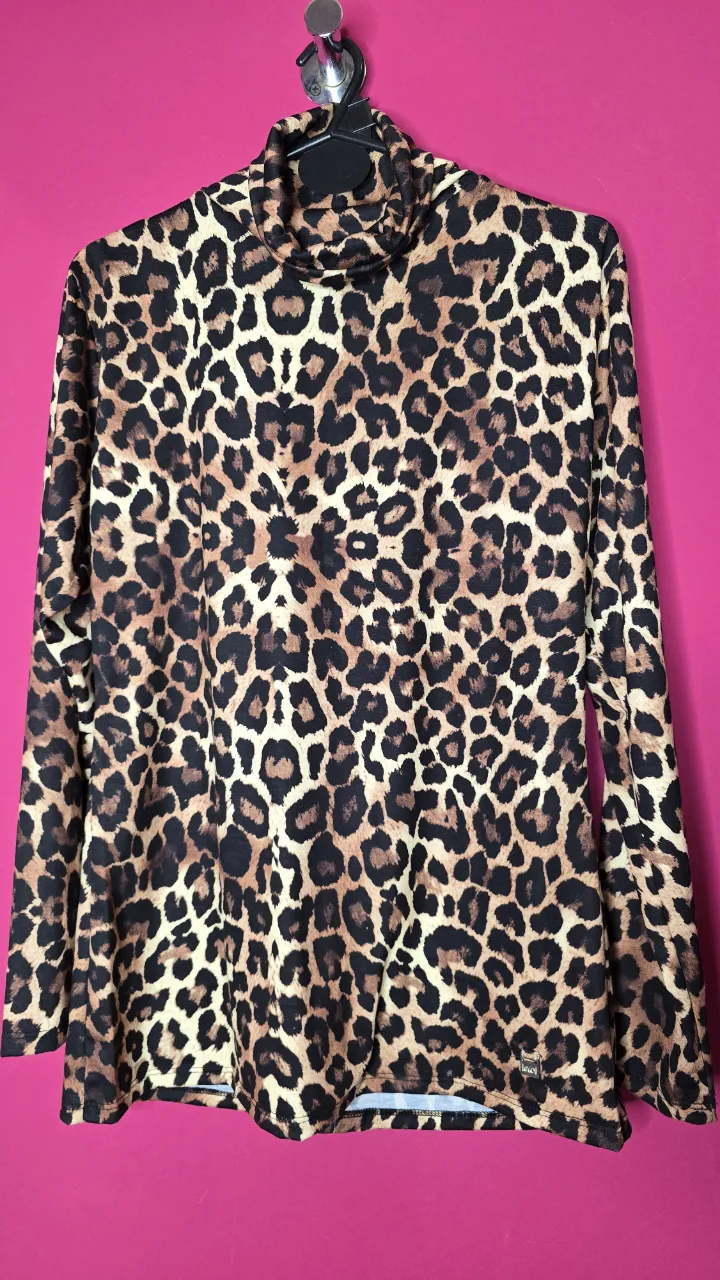 Remera de manga larga con cuello alto y estampado de leopardo. Ideal para un look audaz y moderno.