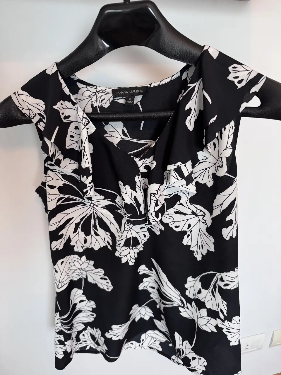 Blusa sin mangas de Banana Republic, volado escote V, con estampado floral en blanco y negro. Ideal para un look elegante y fresco.