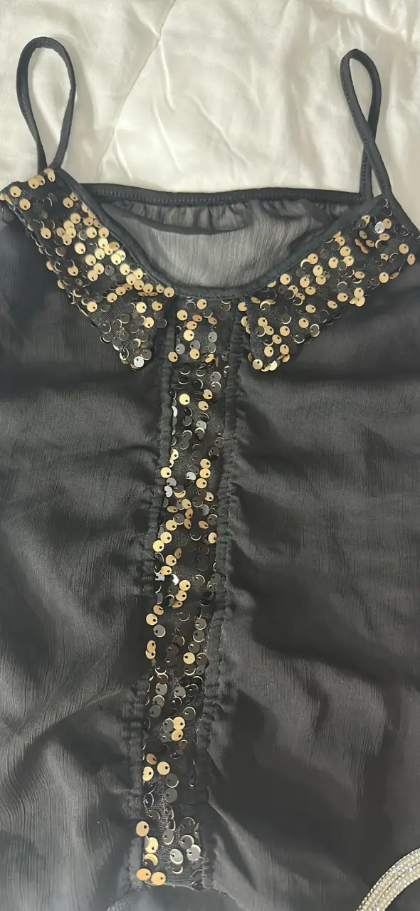 Top negro con detalles dorados de lentejuelas, con transparencia. Ideal para fiestas y eventos especiales. Diseño elegante, sexy y sofisticado.