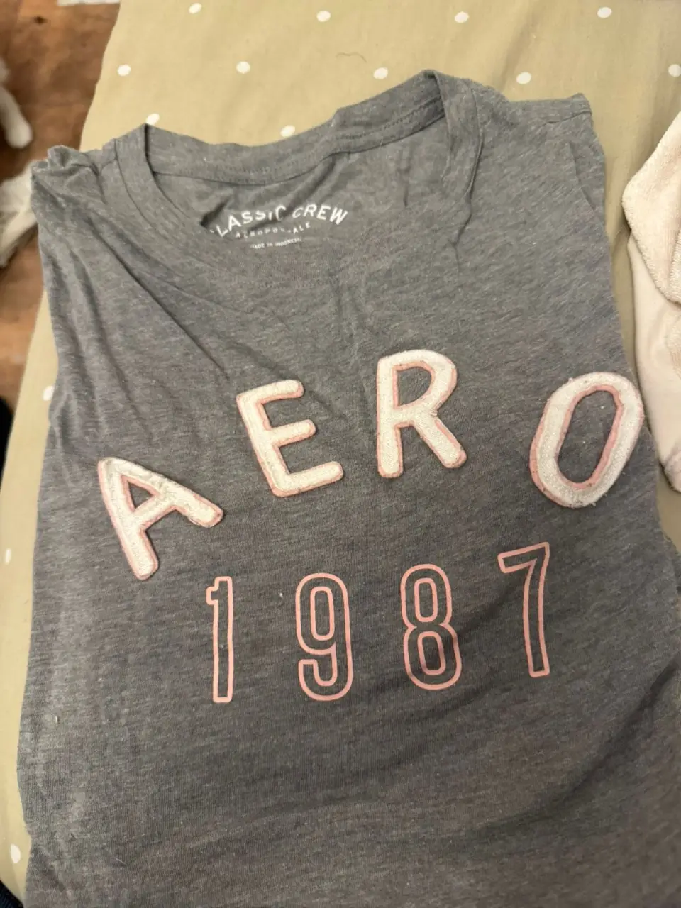 Remera gris de manga corta Aeropostale con estampado "AERO 1987" en color rosa. Ideal para un look casual y cómodo.