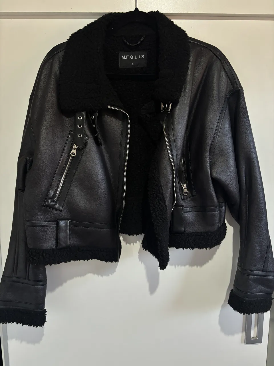 Gamulan de cuero sintético estilo aviador, súper canchera y abrigada. Tiene forro interno de corderito negro, cuello con hebillas y detalles de cierres metálicos. Ideal para un look rocker o urbano.