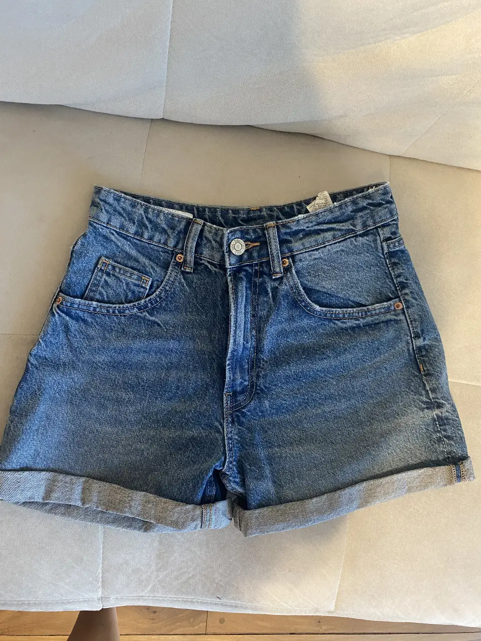 Short de jean de mujer, tiro alto, con dobladillo en el borde. Marca Zara, talle 36 EUR, 4 USA, 26 MEX. Ideal para un look casual y fresco.