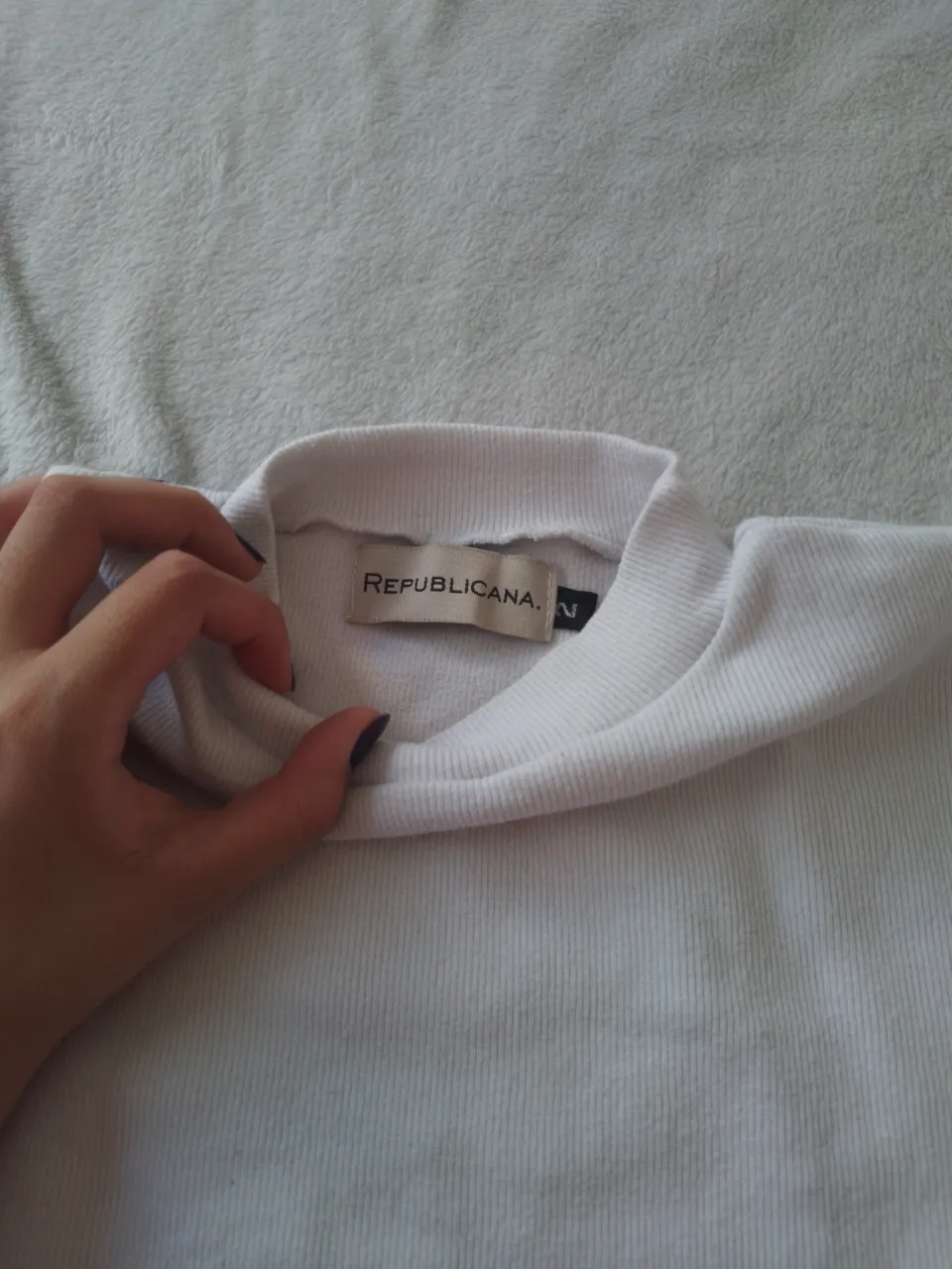 Remera blanca de cuello alto, manga corta y corte al cuerpo. Perfecta para un look casual y moderno.