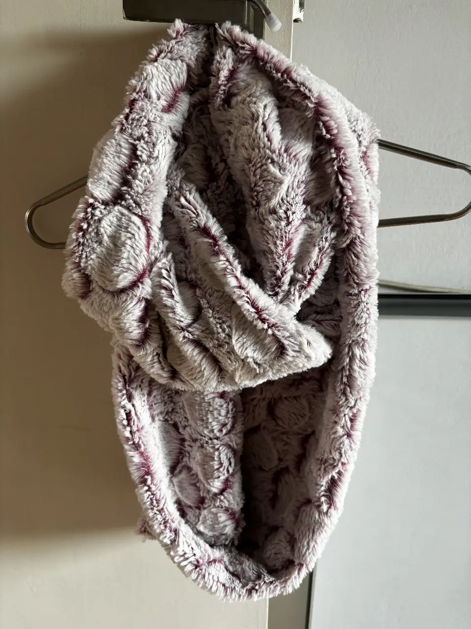 Bufanda circular de piel sintética suave y abrigada, ideal para el invierno. Diseño en tonos grises con detalles en violeta, perfecta para complementar cualquier look casual.