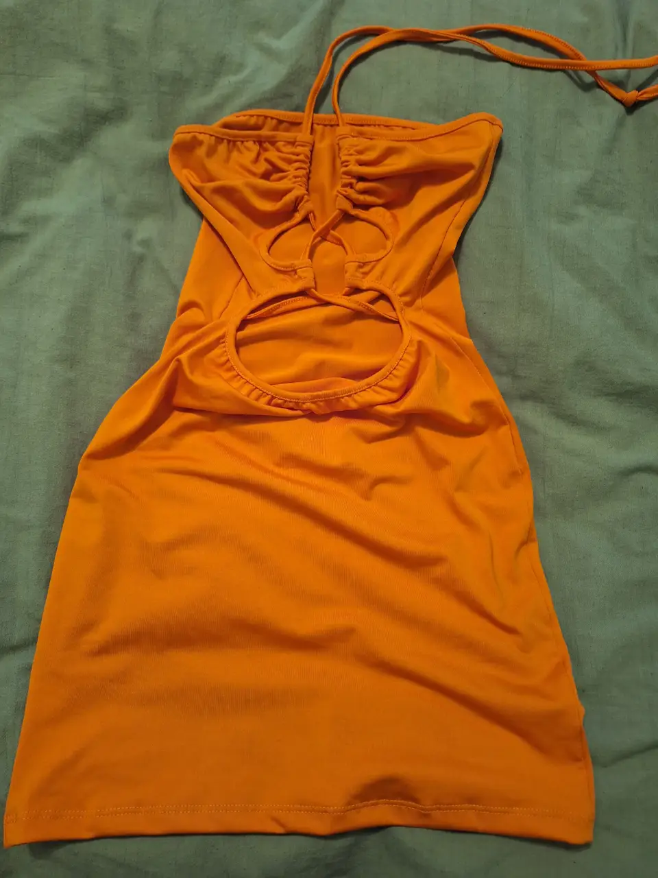 Vestido mini naranja con diseño cut out y tiras ajustables. Ideal para un look de verano fresco y moderno.