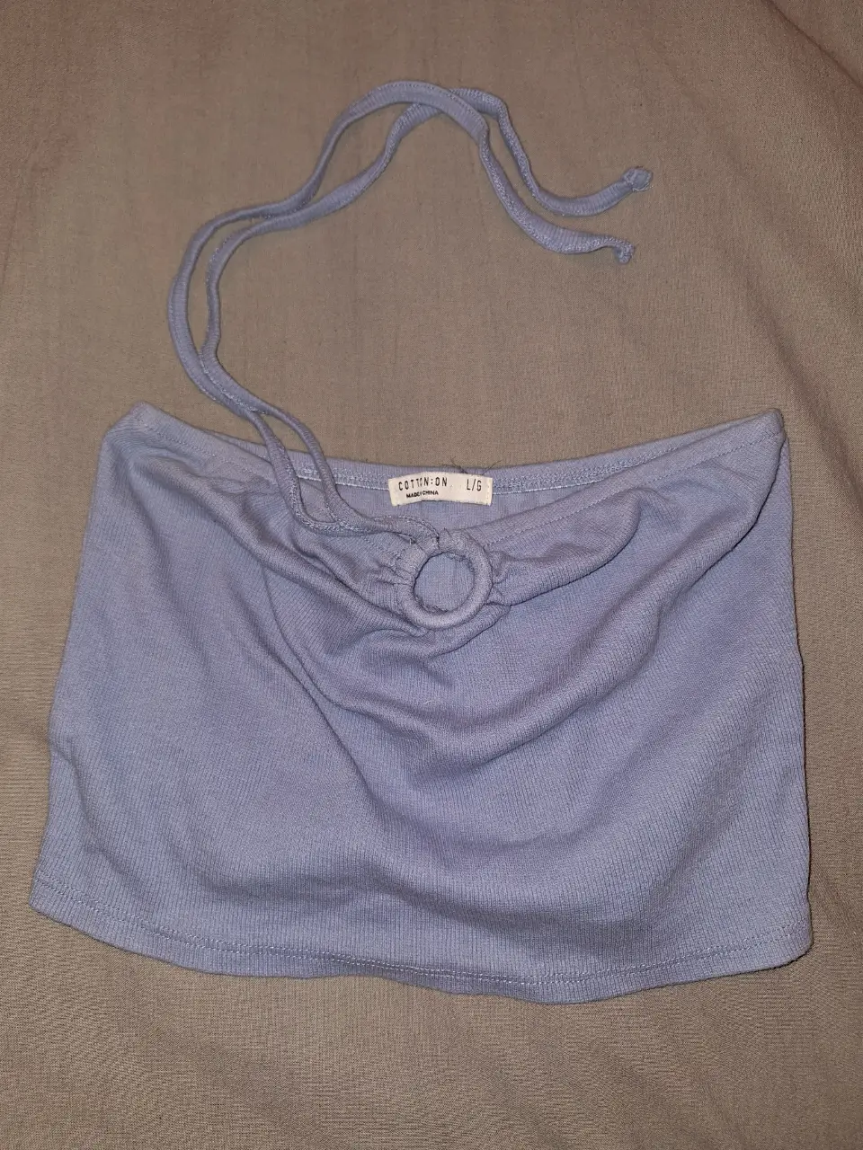 Top celeste de mujer, estilo bandeau con detalle de aro en el centro y tiras ajustables. Ideal para un look casual y fresco.