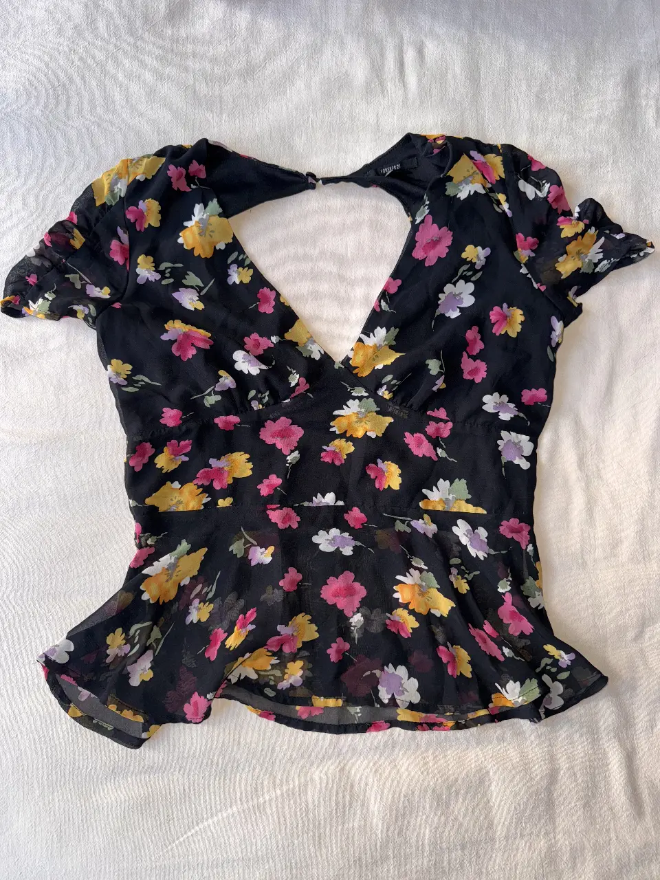 Blusa de Forever 21 con estampado floral en tonos amarillos, rosas y blancos sobre fondo negro. Diseño con escote en V y espalda descubierta, ideal para un look fresco y femenino. (se puede usar de ambos lados)