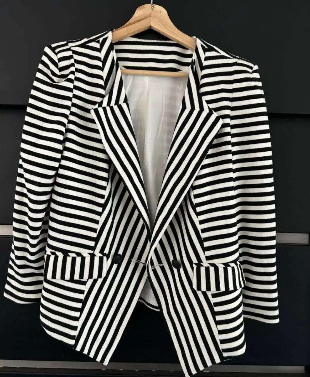 Elegante blazer a rayas blanco y negro, ideal para un look sofisticado y moderno. Perfecto para combinar con diferentes outfits, desde formales hasta casuales.