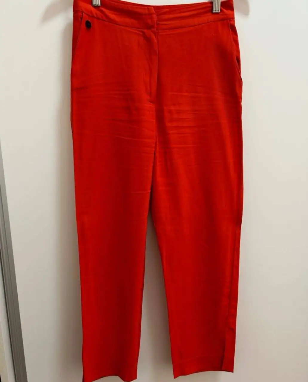Pantalón sastrero rojo, tiro medio, con bolsillos delanteros y traseros. Ideal para un look elegante y moderno.