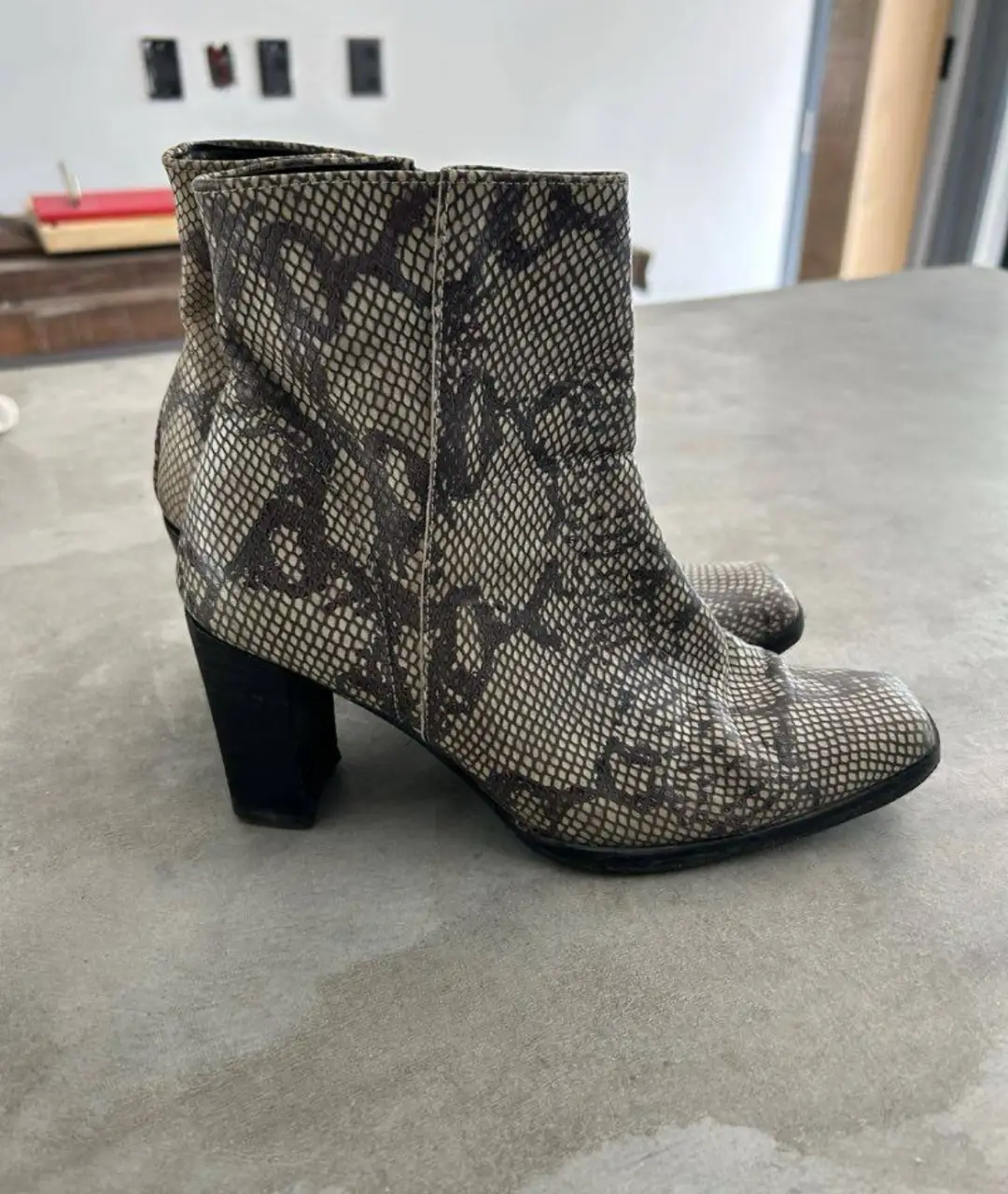 Botines de mujer con estampado de serpiente, taco negro y cierre lateral. Ideales para un look moderno y sofisticado.