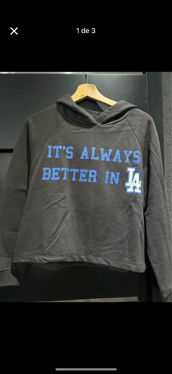 Buzo canguro gris con capucha y estampado "IT'S ALWAYS BETTER IN LA" en azul. Ideal para un look casual y cómodo.