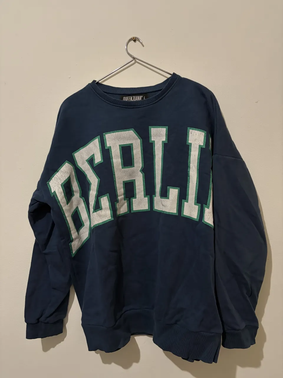 Buzo oversize azul marino con estampa "BERLIN" en blanco y verde. Ideal para un look urbano y relajado.