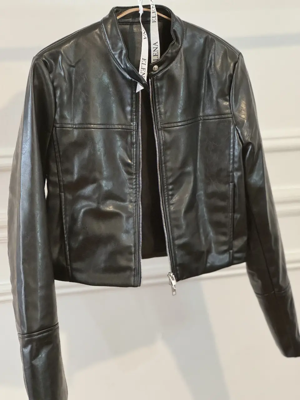 Campera de cuero sintético negra, estilo biker, con cierre frontal y cuello mao. Ideal para un look moderno y versátil.